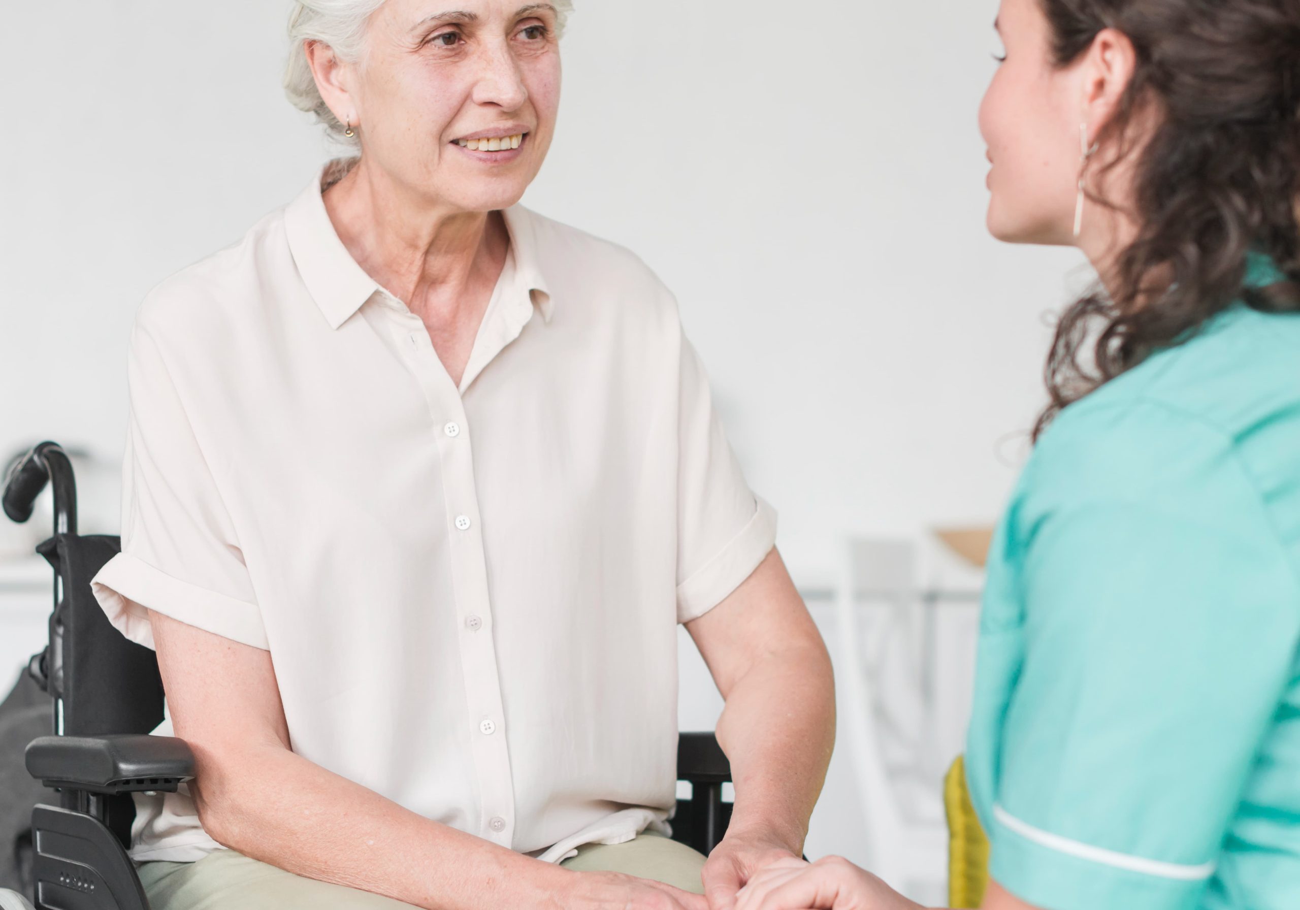 happy-disabled-nurse-sitting-wheel-chair-looking-caretaker (1)